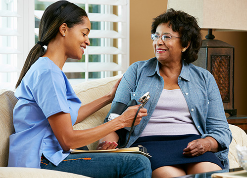 Photo of a nurse checking the blood pressure of her patient